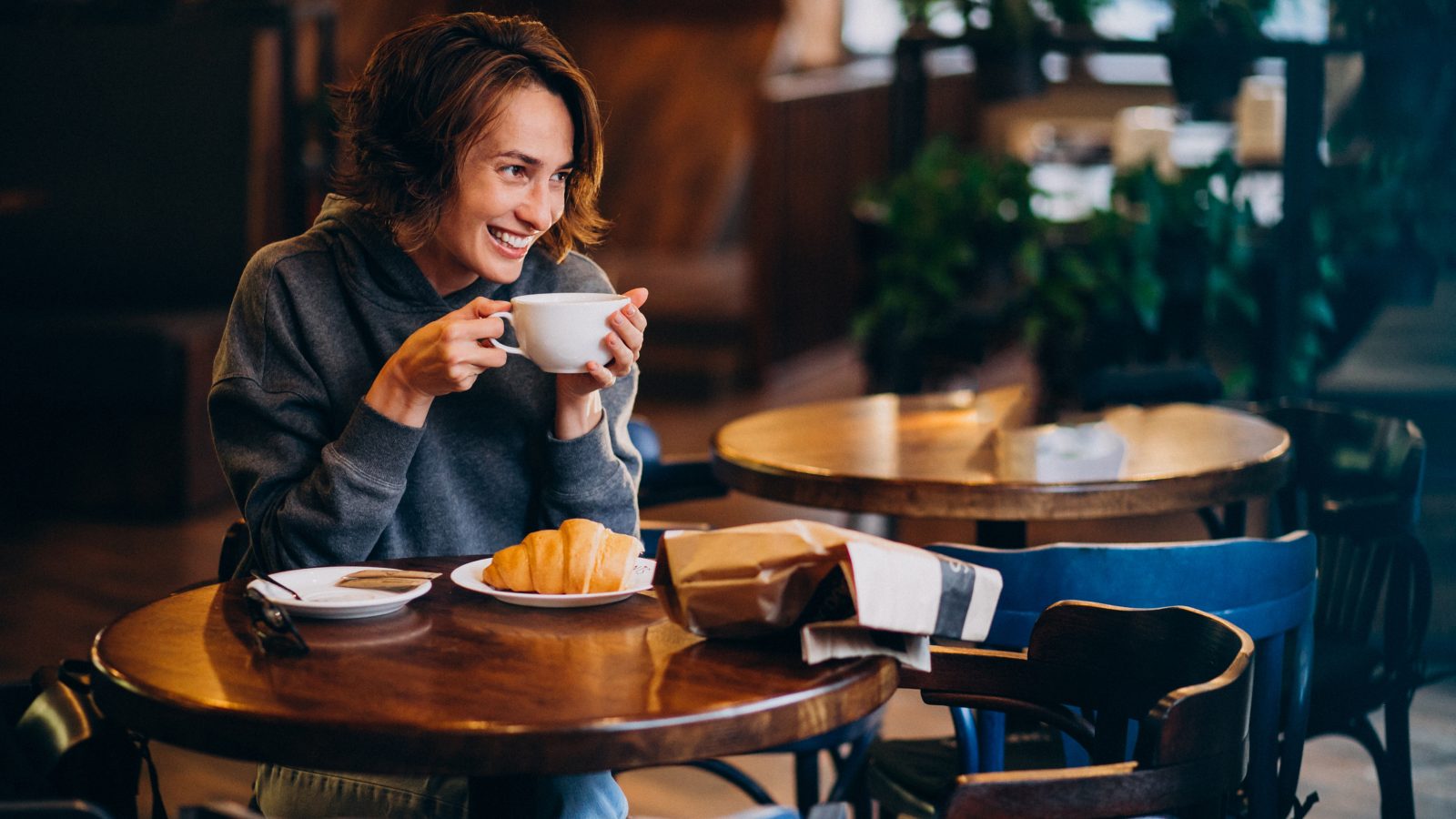 a woman sitting at a table with a cup of coffee at The 