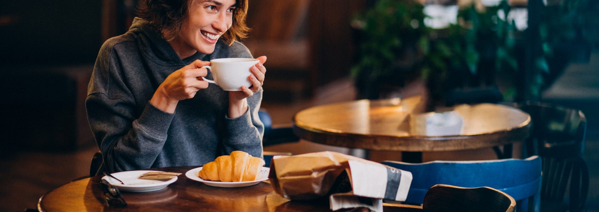 a woman sitting at a table with a cup of coffee at The 