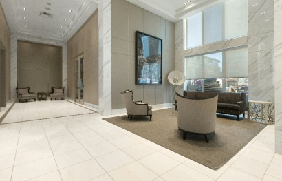 the lobby of a luxury apartment building with a large marble floor at The 