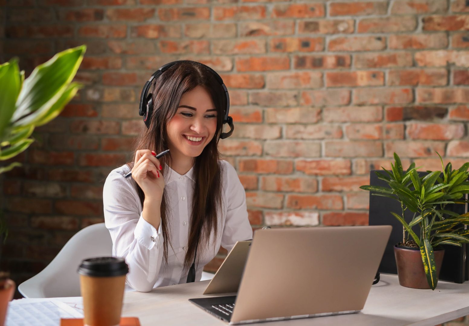 a woman is smiling while working on her laptop at The 