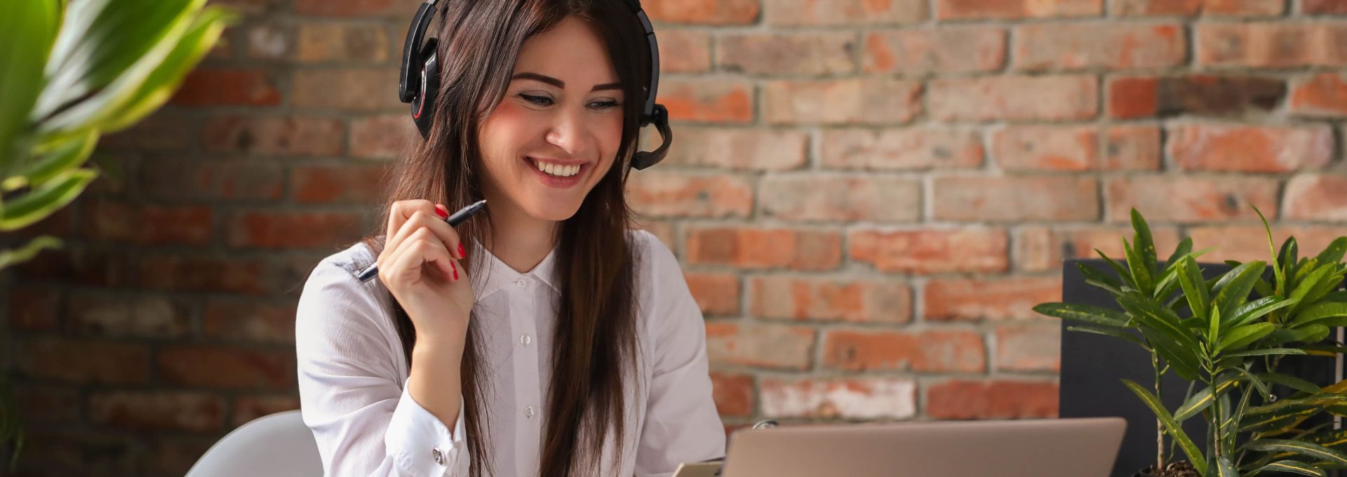 a woman is smiling while working on her laptop at The 